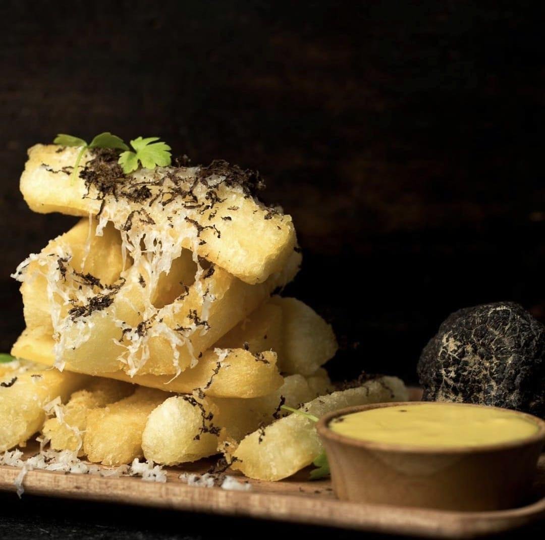 Stacked yuca fries with shaved black truffle, grana padano and a pot of aji crema